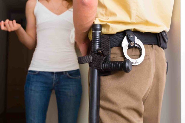 Polizist steht vor der Haustüre für eine Hausdurchsuchung
