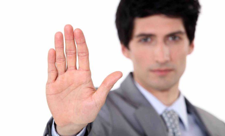 Mann zeigt mit Handfläche in Kamera