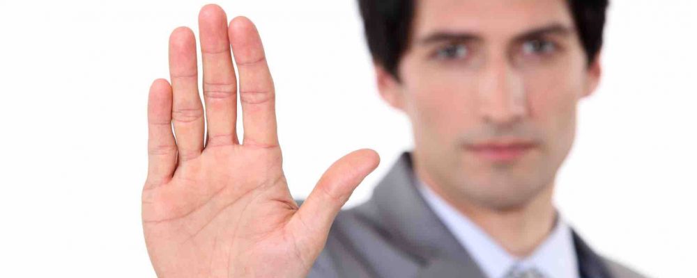 Mann zeigt mit Handfläche in Kamera